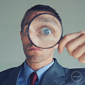 Man im Anzug mit Lupe: Warum ist SEO wichtig?