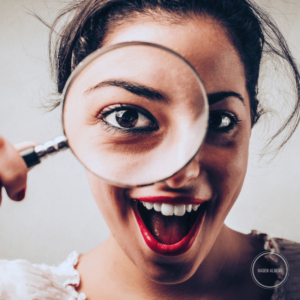 Junge Frau mit Lupe: Wie lange dauert SEO?